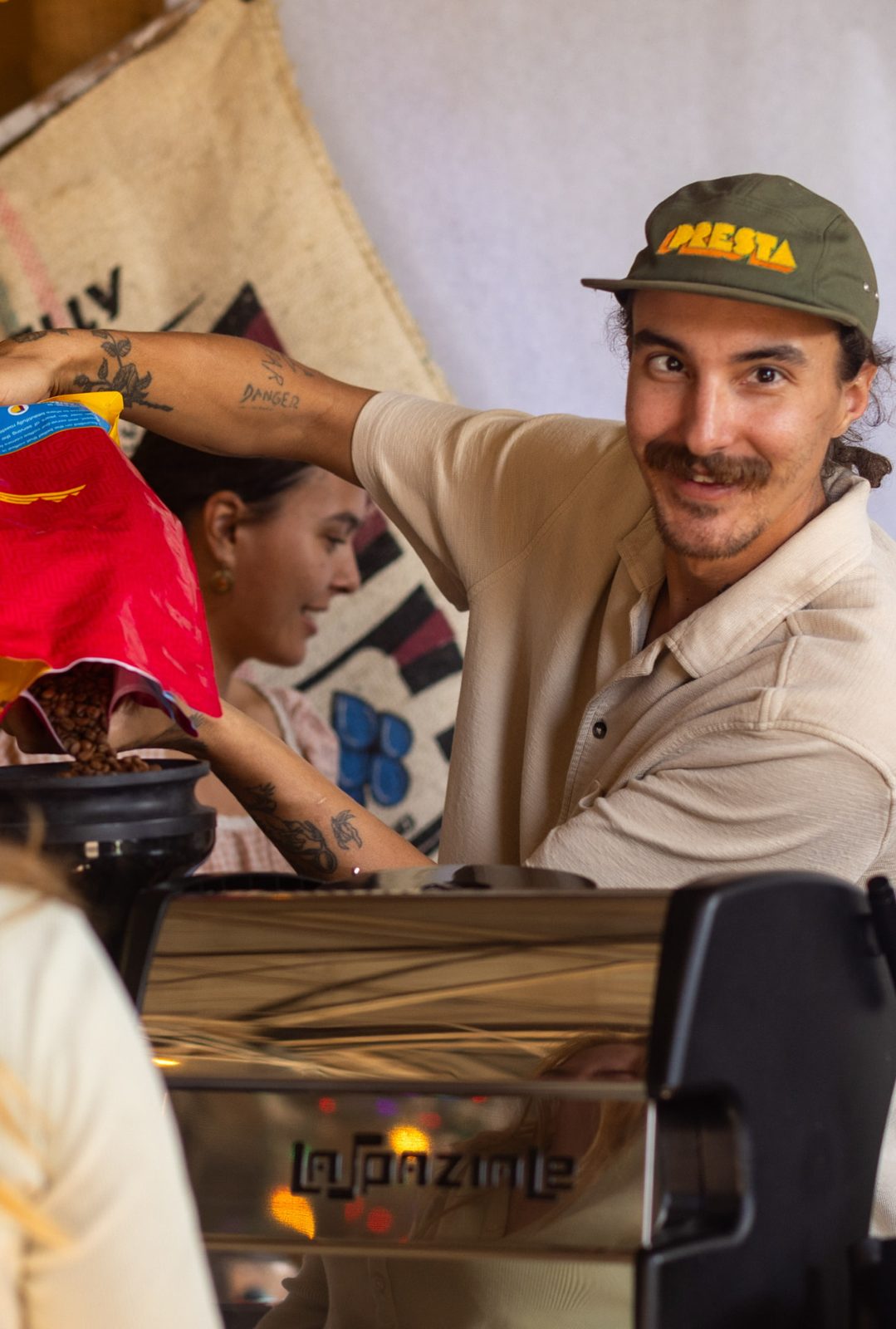 A Slow Down Coffee barista pouring coffee beans into the grinder